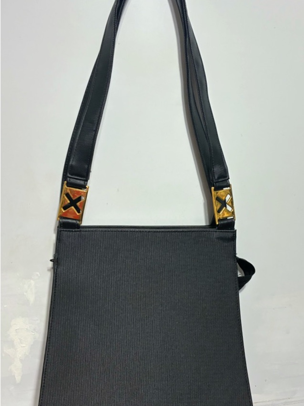 Unusual black rectangle purse hard with gold cut out x’s has sheen